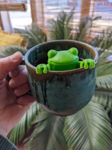cup of green with frog infuser